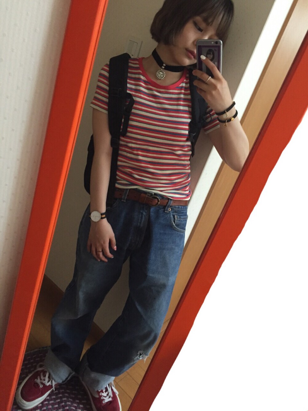 レッド系のTシャツ/カットソー、ブルー系のデニムパンツ、レッド系のスニーカーを着用したレディースの夏コーディネートの1枚目の写真