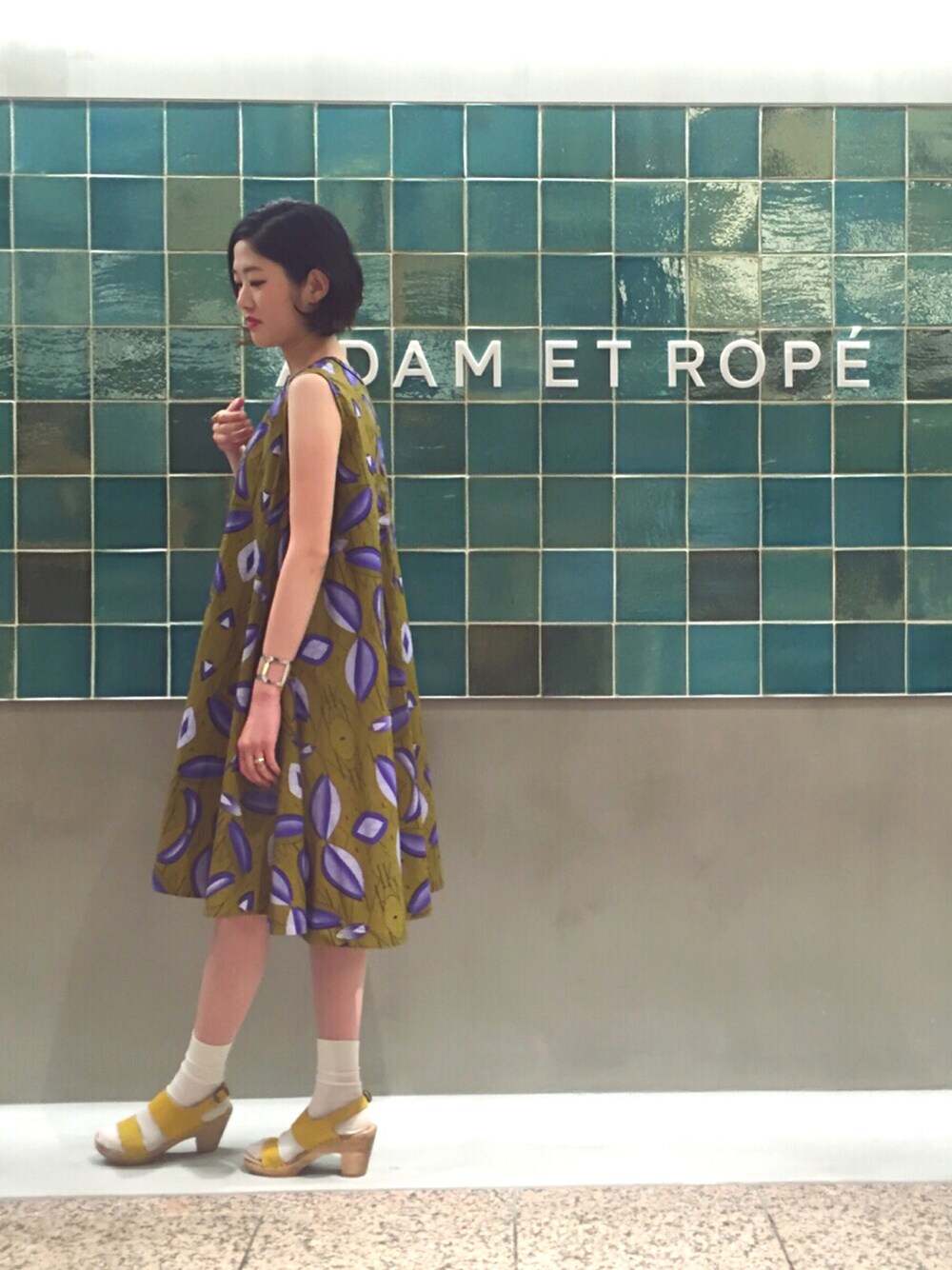 イエロー系のワンピース/ドレス、イエロー系のサンダル、シルバー系のバングル/リストバンドを着用したレディースの春コーディネートの1枚目の写真