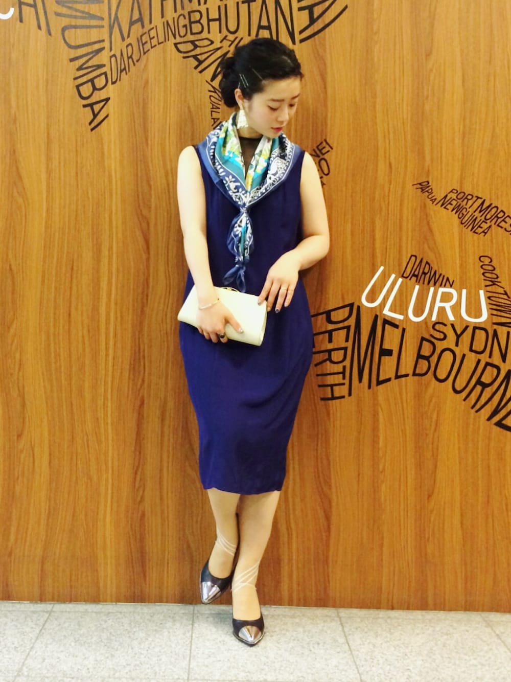 ホワイト系のクラッチバッグ、ワンピース、ブラック系のパンプスを着用したレディースの春コーディネートの1枚目の写真