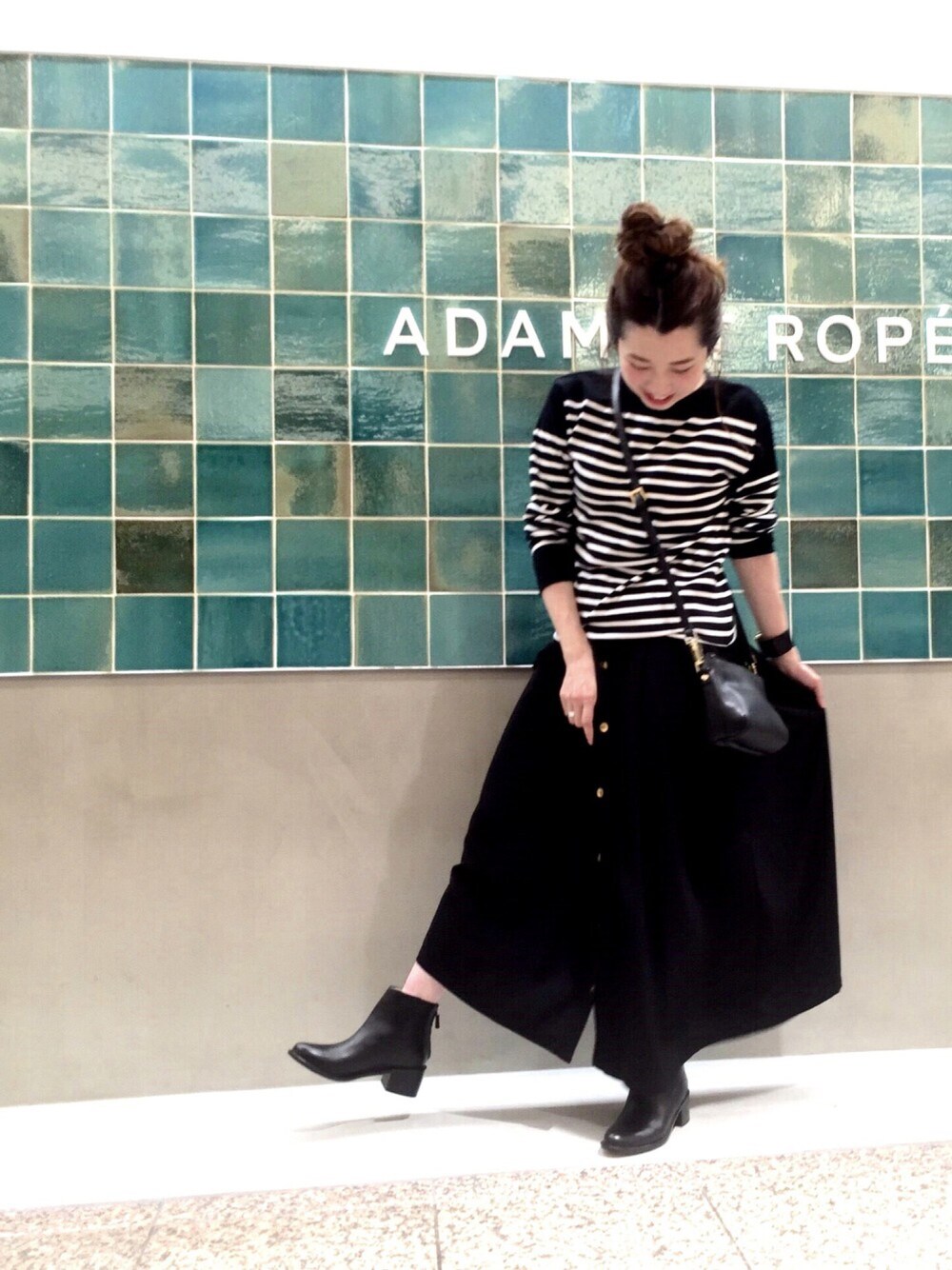 ブラック系のスカート、ブラック系のTシャツ/カットソー、ブラック系のブーツを着用したレディースの夏コーディネートの1枚目の写真