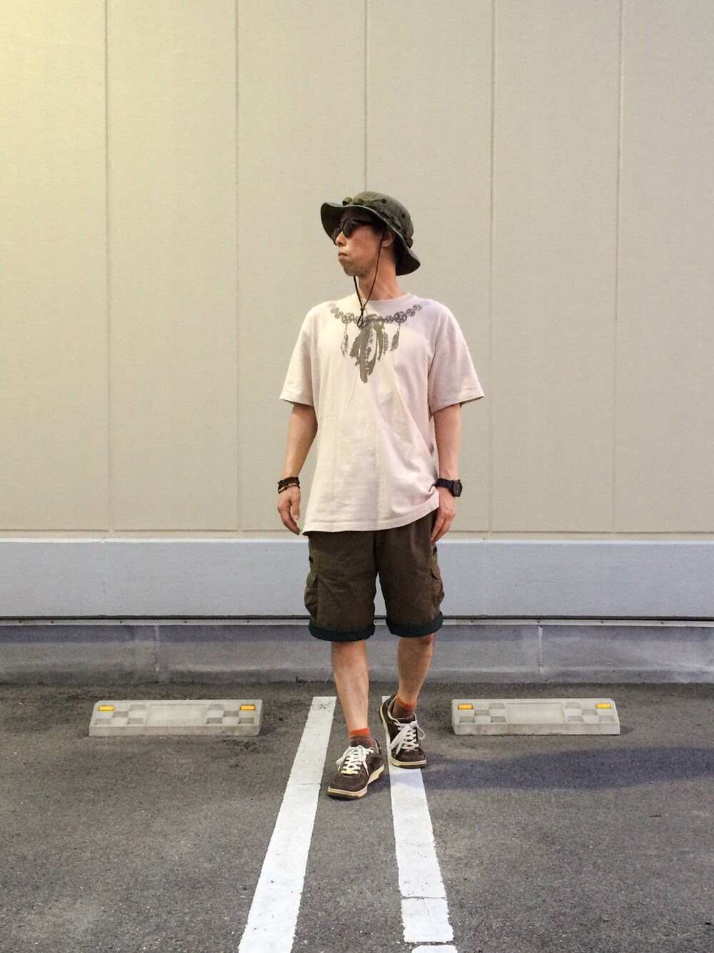 ベージュ系のTシャツ/カットソー、グリーン系のその他パンツ、ブラウン系のスニーカーを着用したメンズの夏コーディネートの1枚目の写真