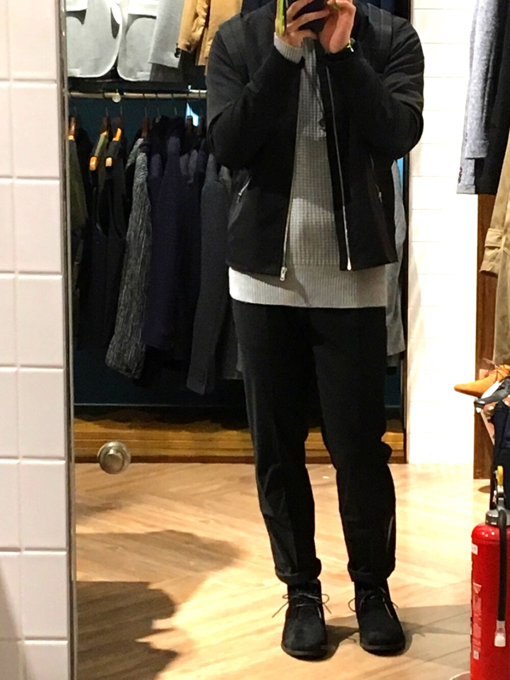 グレー系のニット/セーター、ブラック系のスラックス、ブラック系のMA-1を着用したメンズの冬コーディネートの1枚目の写真