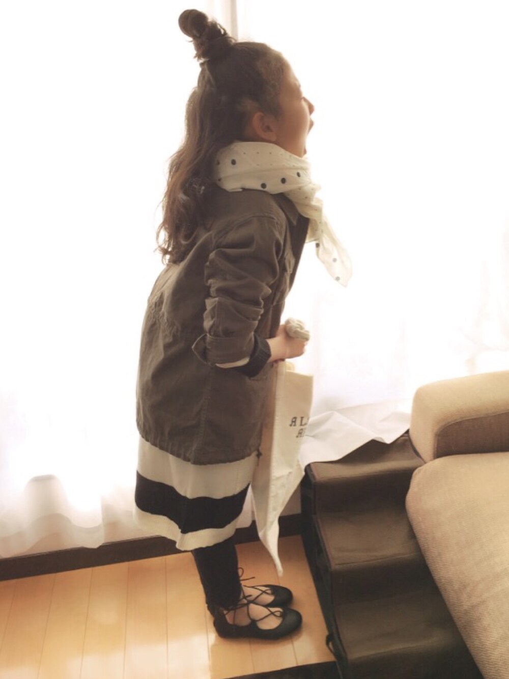 ホワイト系のワンピース、グリーン系のミリタリージャケット、ブラック系のパンプスを着用したキッズの冬コーディネートの1枚目の写真