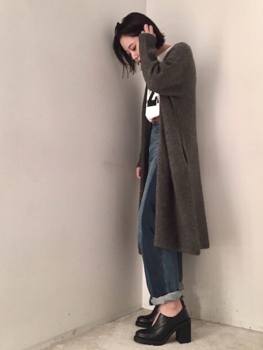 グレー系のカーディガン/ボレロ、ホワイト系のTシャツ/カットソー、ブルー系のデニムパンツを着用したレディースの秋コーディネートの1枚目の写真