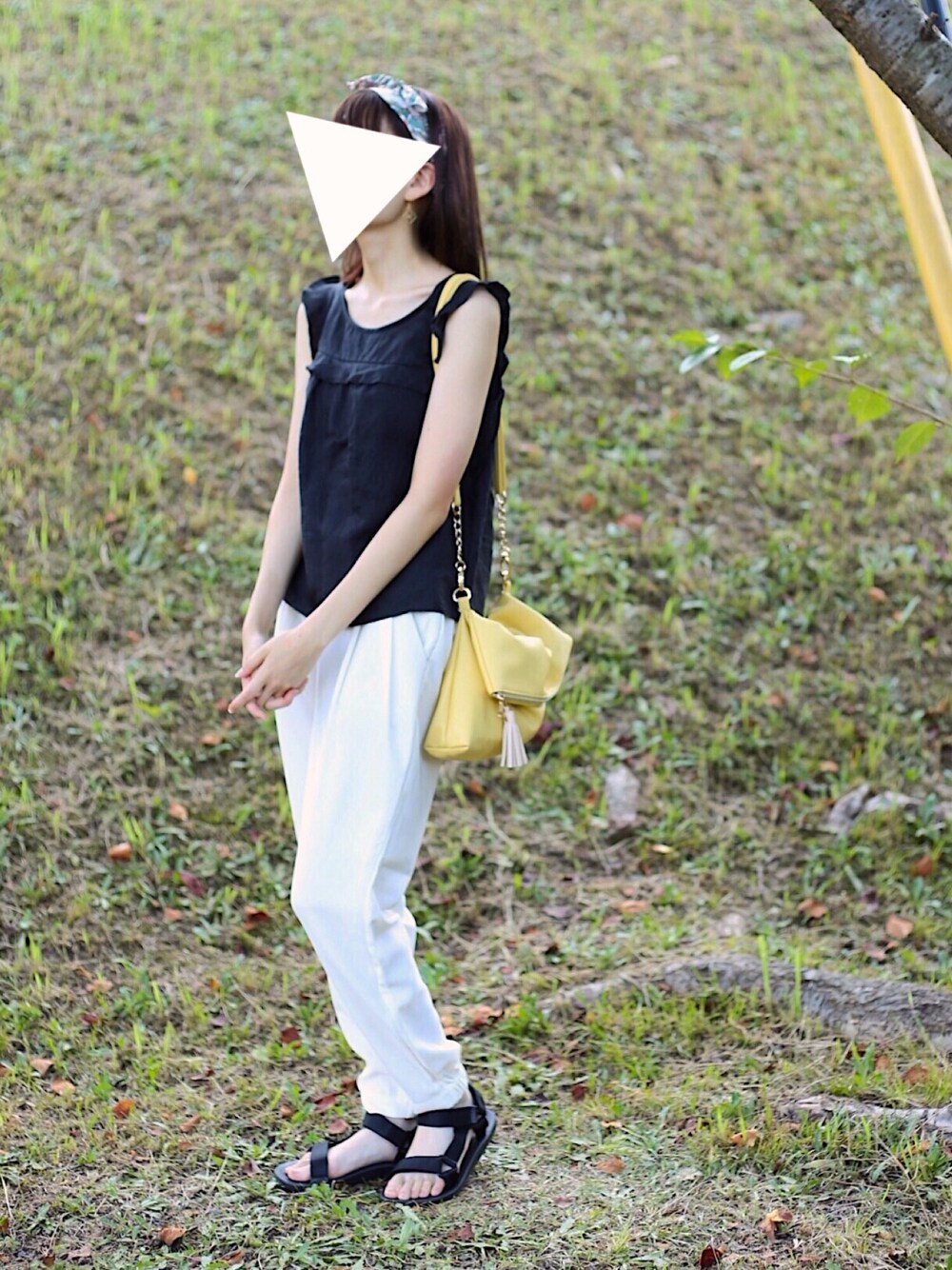 ホワイト系のパンツ、ブラック系のサンダル、シルバー系の香水を着用したレディースの秋コーディネートの1枚目の写真