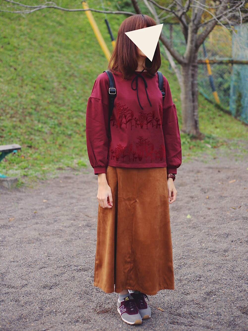 レッド系のTシャツ/カットソー、ブラウン系のスカート、レッド系のスニーカーを着用したレディースの冬コーディネートの1枚目の写真