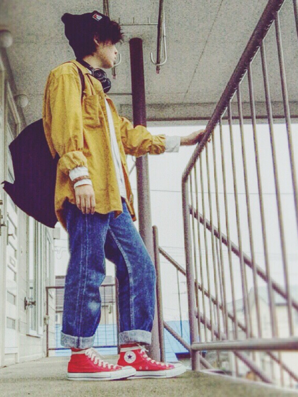 ブルー系のデニムパンツ、レッド系のスニーカー、イエロー系のシャツ/ブラウスを着用したレディースの秋コーディネートの1枚目の写真