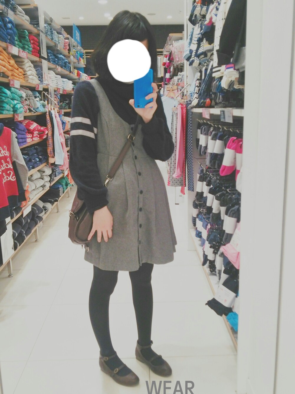 グレー系のスカート、ブラウン系のパンプス、ブルー系のニット/セーターを着用したレディースの冬コーディネートの1枚目の写真