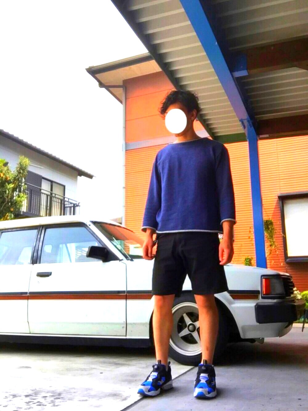 ブルー系のスウェット、イエロー系のタンクトップ、ブルー系のスニーカーを着用したメンズの春コーディネートの1枚目の写真