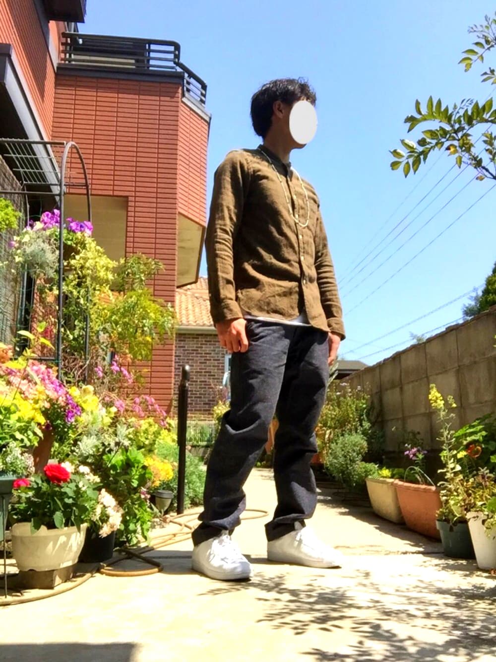 グリーン系のシャツ/ブラウス、ホワイト系のTシャツ/カットソー、ブルー系のスラックスを着用したメンズの春コーディネートの1枚目の写真