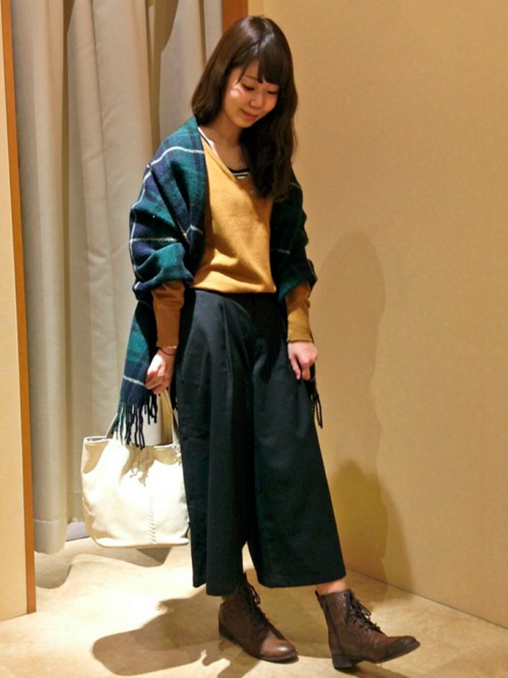 ブラウン系のニット/セーター、ブラック系のその他パンツ、ホワイト系のトートバッグを着用したレディースの冬コーディネートの1枚目の写真