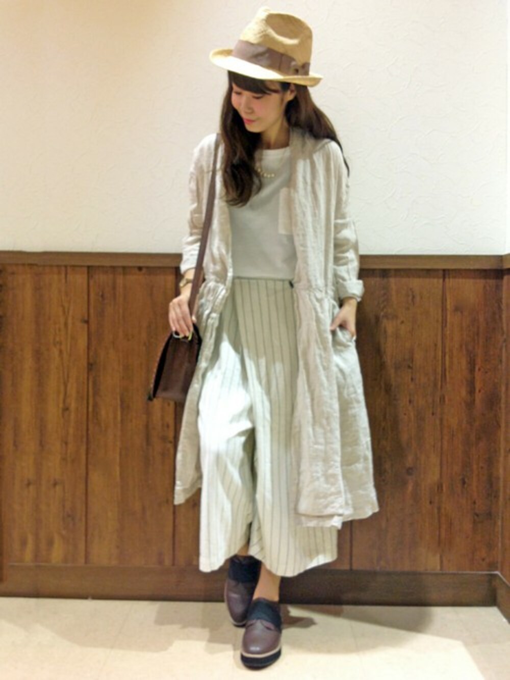 ブラウン系のショルダーバッグ、ホワイト系のその他パンツ、ホワイト系のステンカラーコートを着用したレディースの春コーディネートの1枚目の写真
