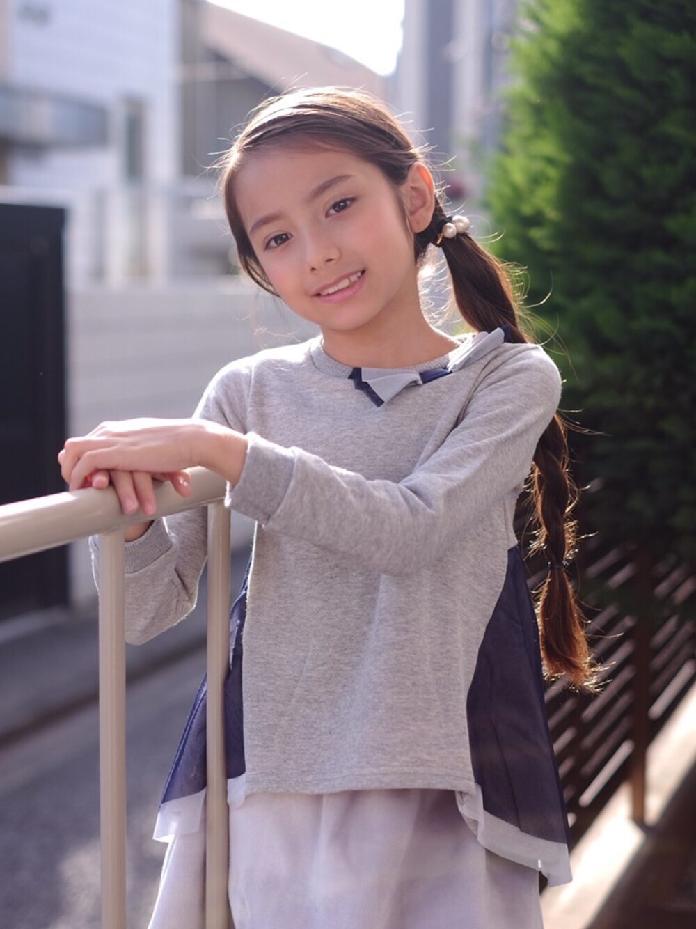 グレー系のその他トップス、ホワイト系のヘアゴムを着用したキッズの冬コーディネートの1枚目の写真