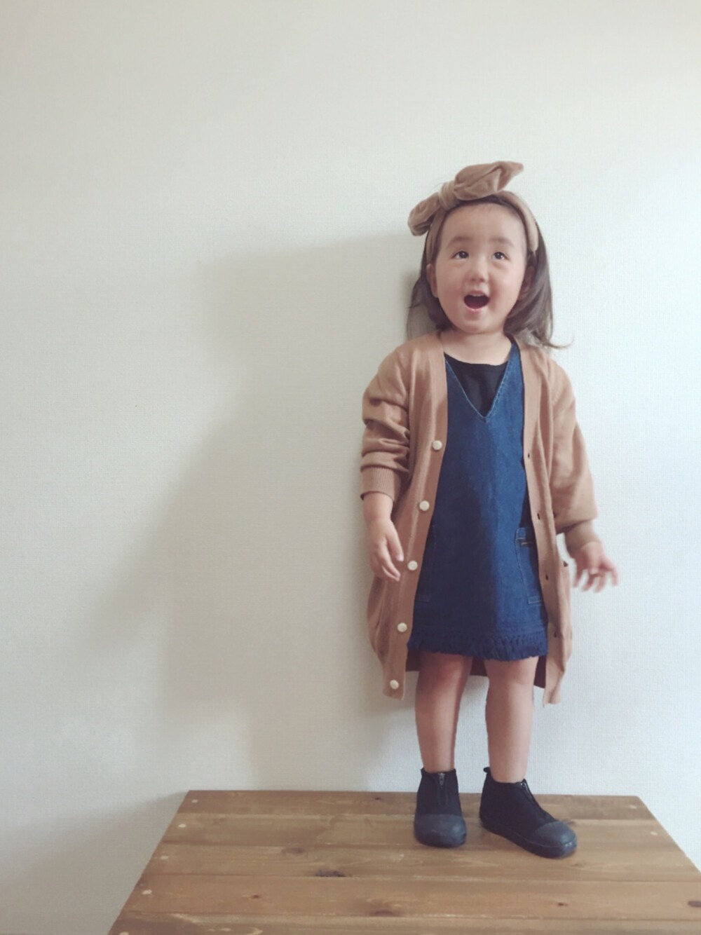 ブラウン系のカーディガン/ボレロ、ブラック系のタンクトップ、ブルー系のワンピースを着用したキッズの秋コーディネートの1枚目の写真