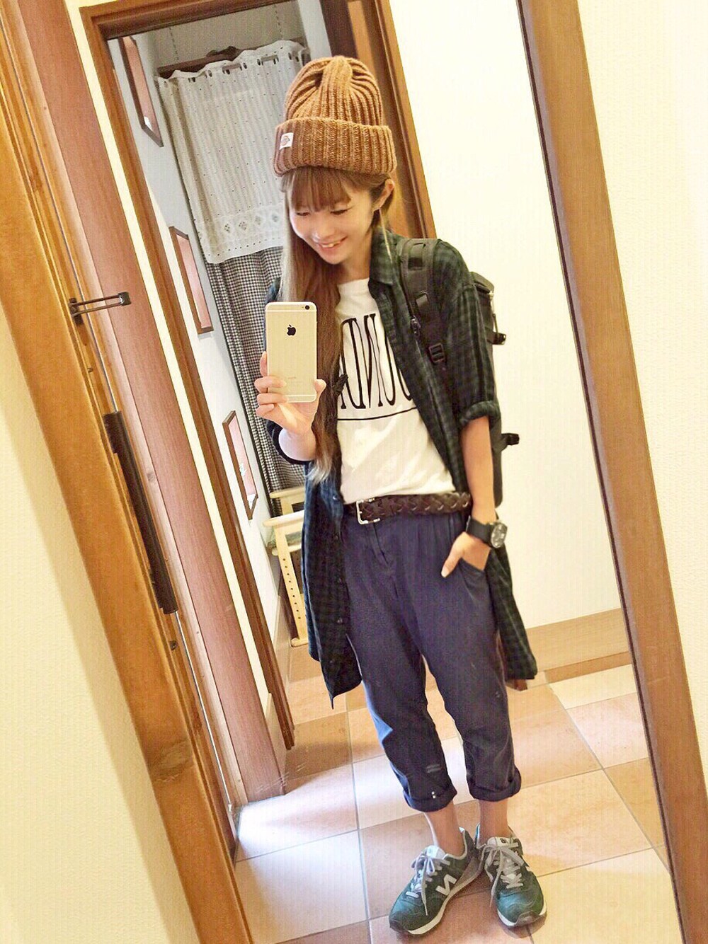 グリーン系のワンピース、ベージュ系のTシャツ/カットソー、ブラック系のバックパック/リュックを着用したレディースの秋コーディネートの1枚目の写真