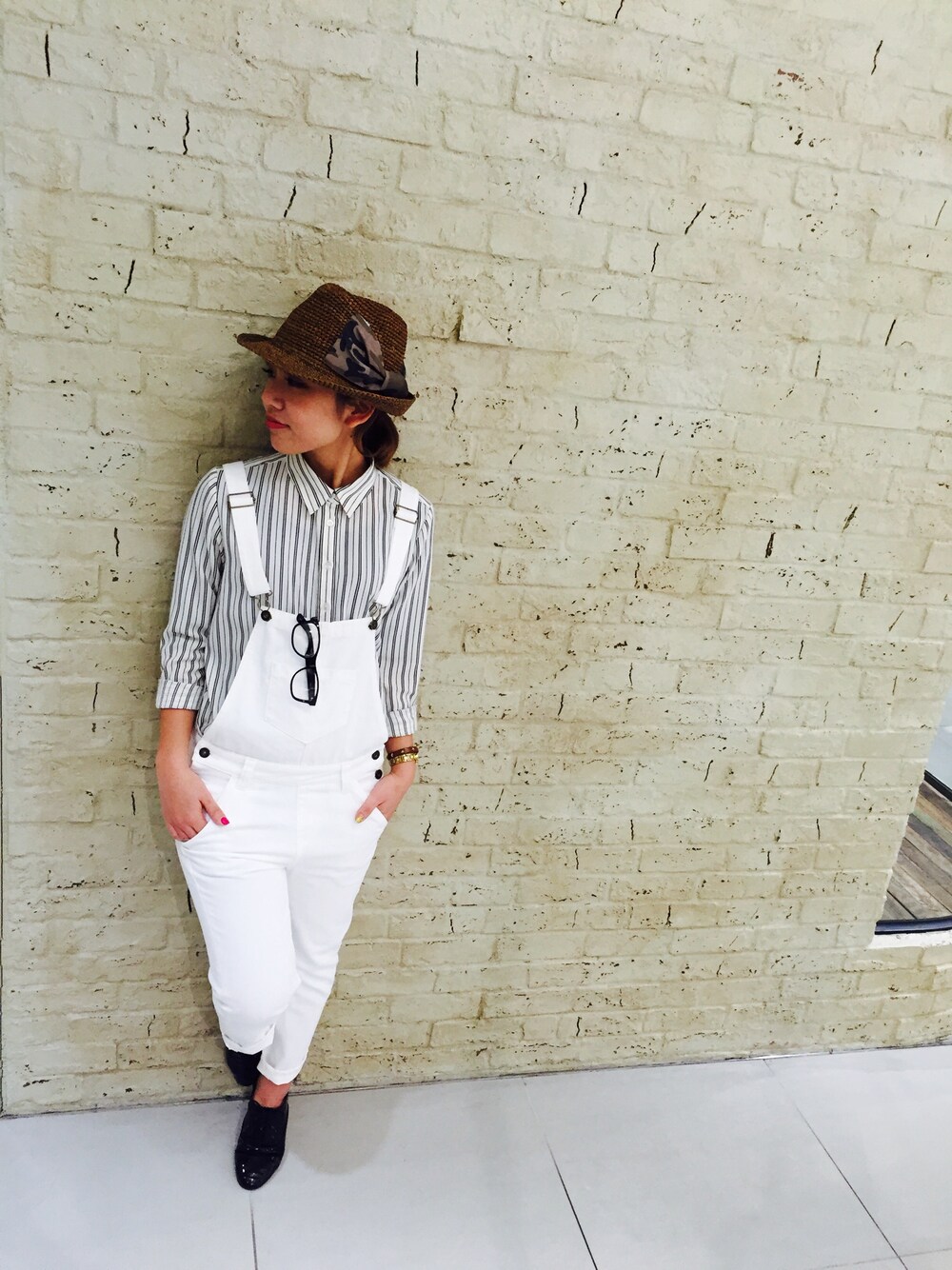 ホワイト系のシャツ/ブラウス、ブルー系のサロペット/オーバーオール、ブラウン系のハットを着用したレディースの冬コーディネートの1枚目の写真