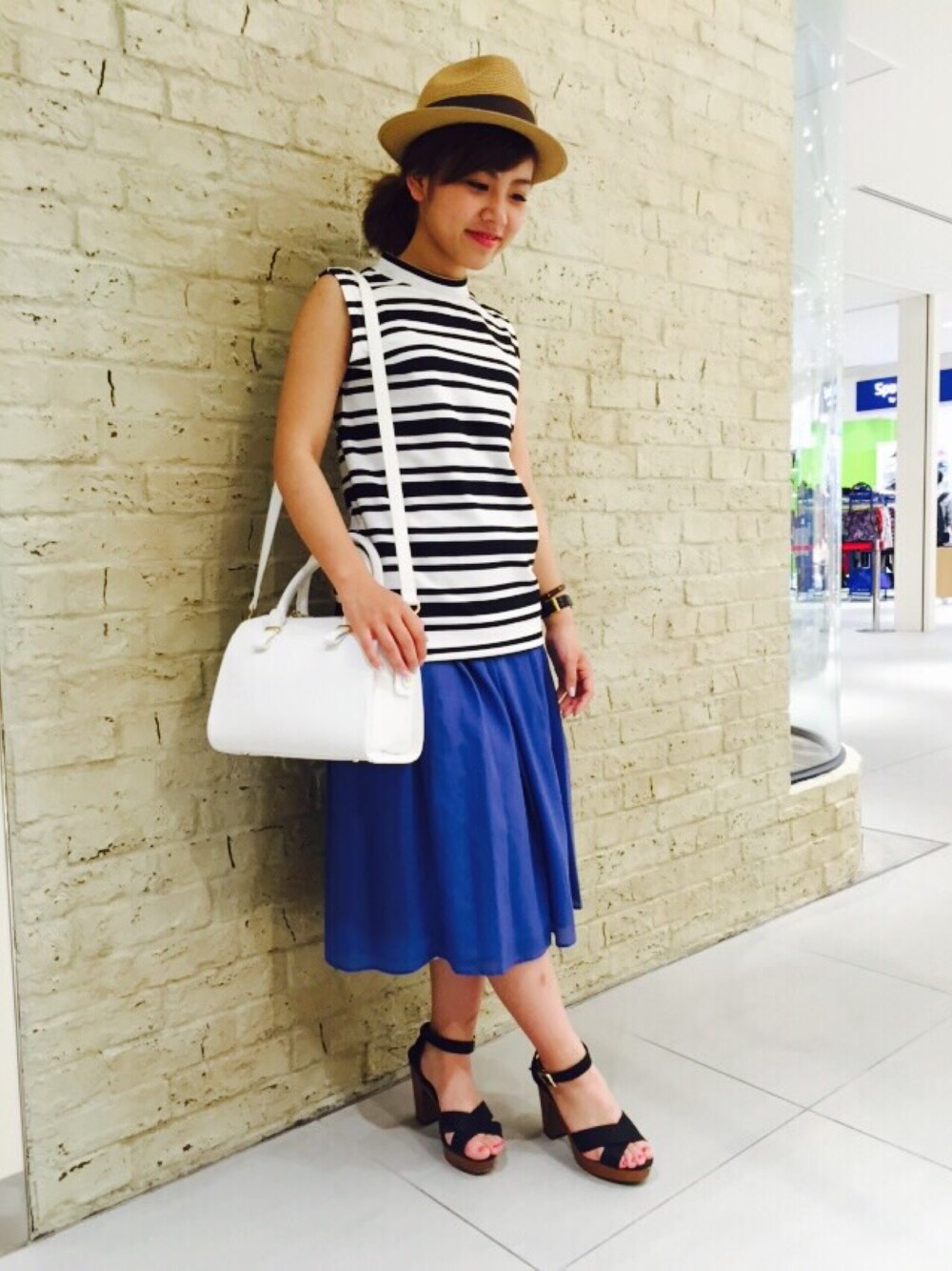 ブラック系のTシャツ/カットソー、ブラック系のサンダル、ホワイト系のボストンバッグを着用したレディースの夏コーディネートの1枚目の写真