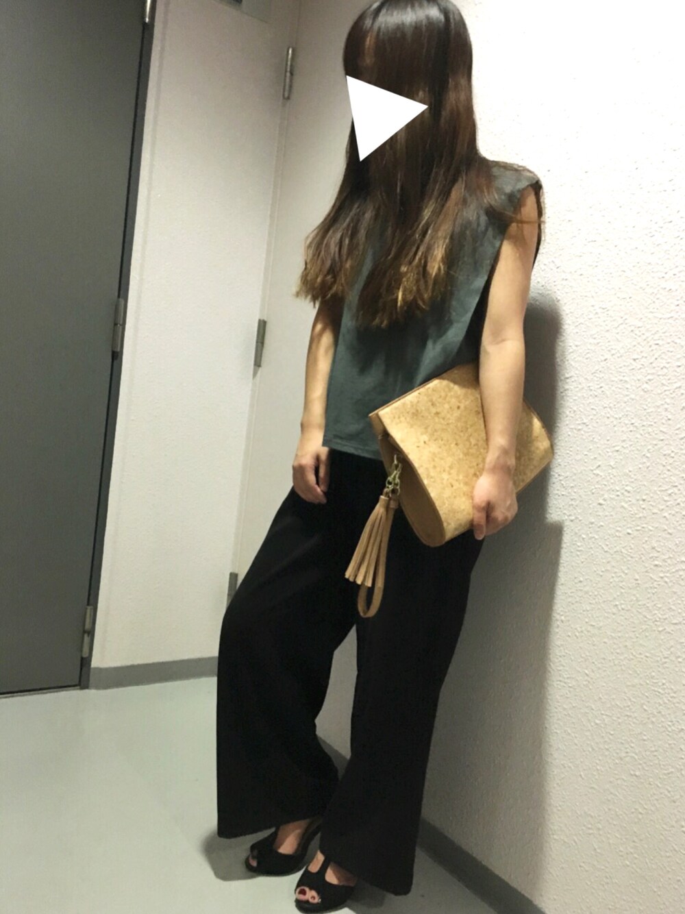 グレー系のタンクトップ、ブラック系のその他パンツ、ブラウン系のクラッチバッグを着用したレディースの夏コーディネートの1枚目の写真