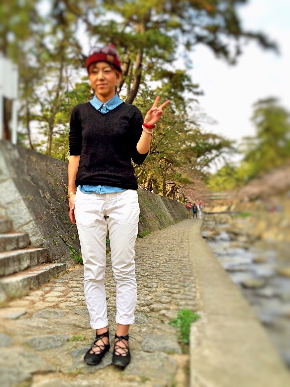 ブルー系のシャツ/ブラウス、ブラック系のニット/セーター、ホワイト系のその他パンツを着用したレディースの春コーディネートの1枚目の写真