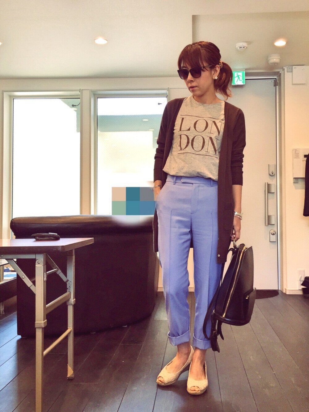 グレー系のTシャツ/カットソー、ブラウン系のカーディガン/ボレロ、ブラック系のバックパック/リュックを着用したレディースの春コーディネートの1枚目の写真