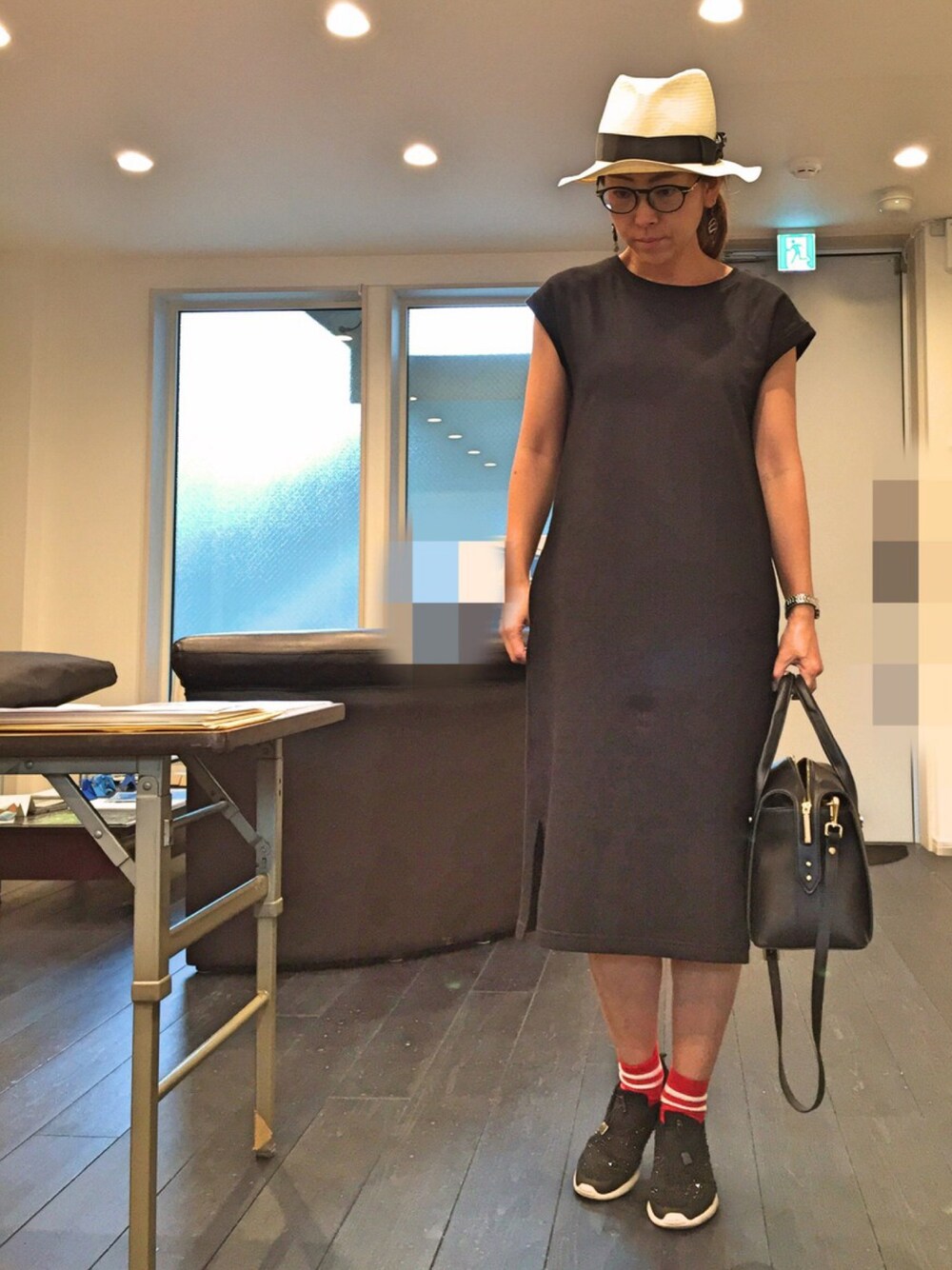 ブラック系のワンピース、ブラック系のハンドバッグ、ブラック系のスニーカーを着用したレディースの秋コーディネートの1枚目の写真