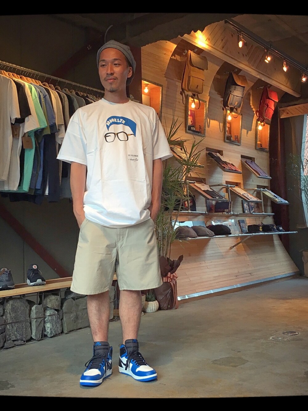 ホワイト系のTシャツ/カットソー、ベージュ系のチノパンツ、ブルー系のスニーカーを着用したメンズの夏コーディネートの1枚目の写真