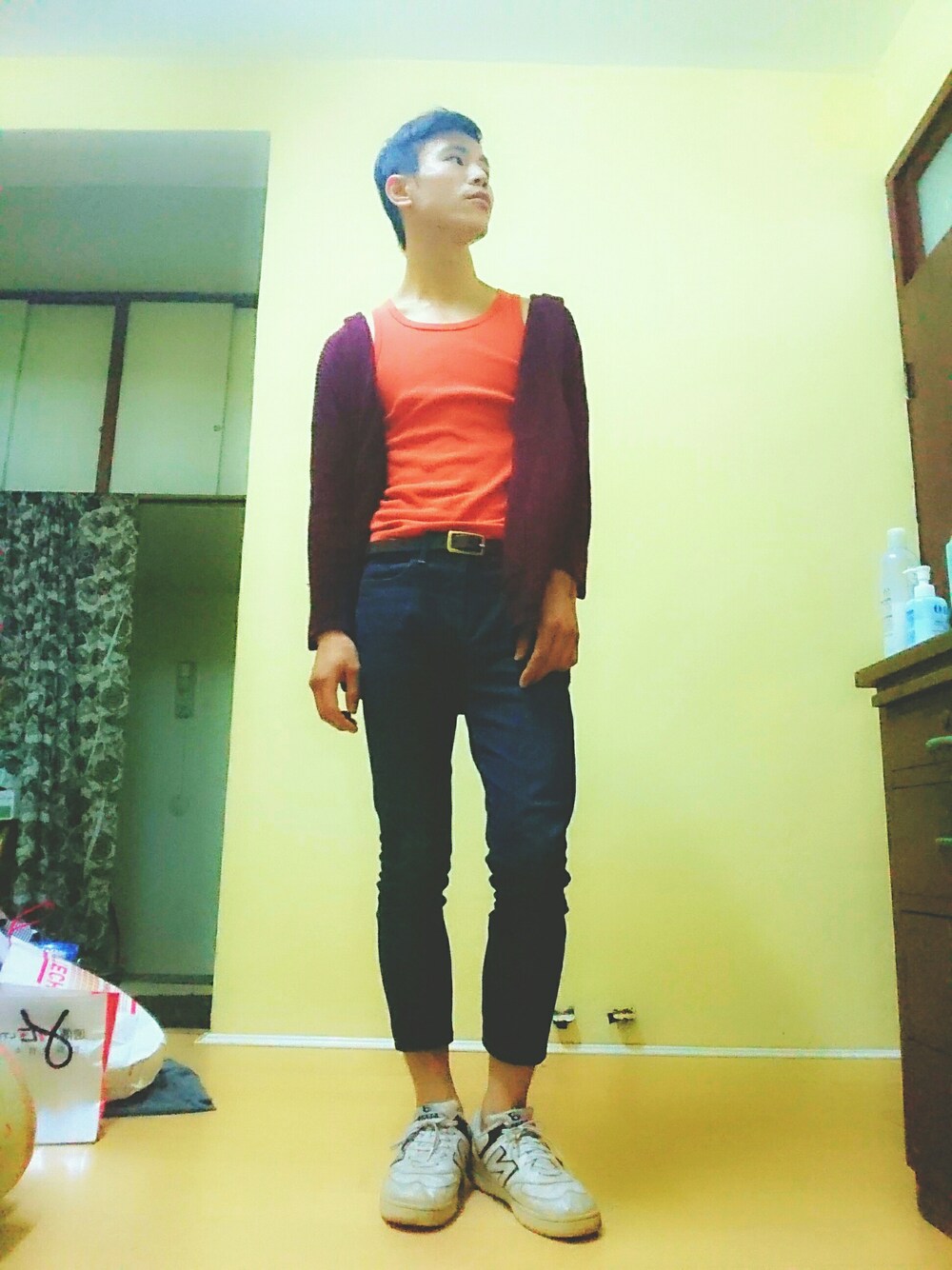 ブルー系のパンツ、レッド系のトップス、ホワイト系のシューズを着用したメンズの秋コーディネートの1枚目の写真