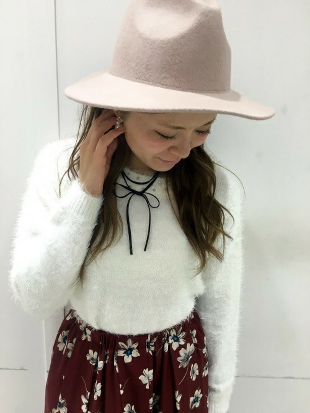 レッド系のスカート、ピンク系のハットを着用したレディースの秋コーディネートの1枚目の写真