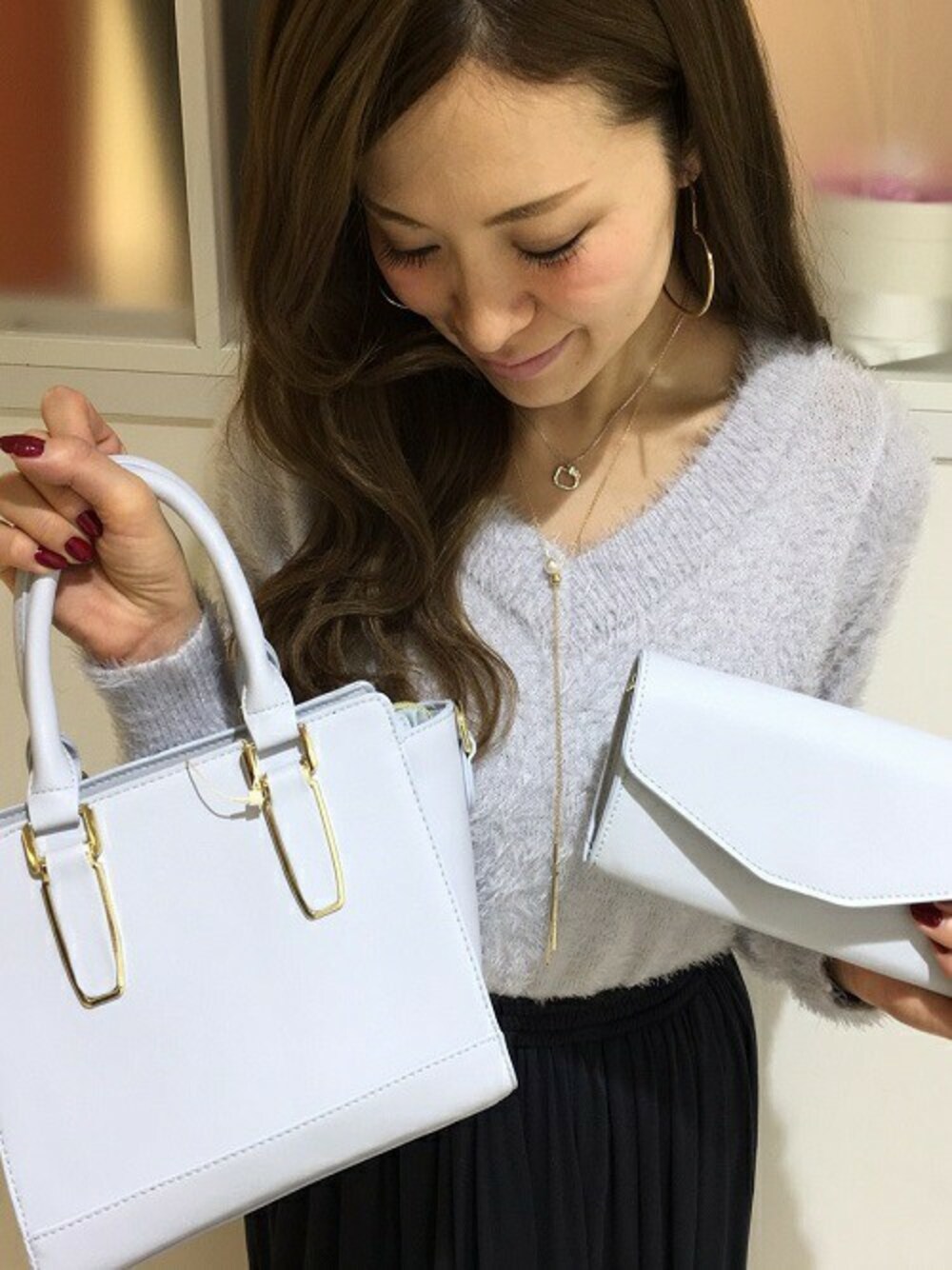 ブルー系のショルダーバッグ、ブルー系のニット/セーター、ブルー系のスカートを着用したレディースの秋コーディネートの1枚目の写真