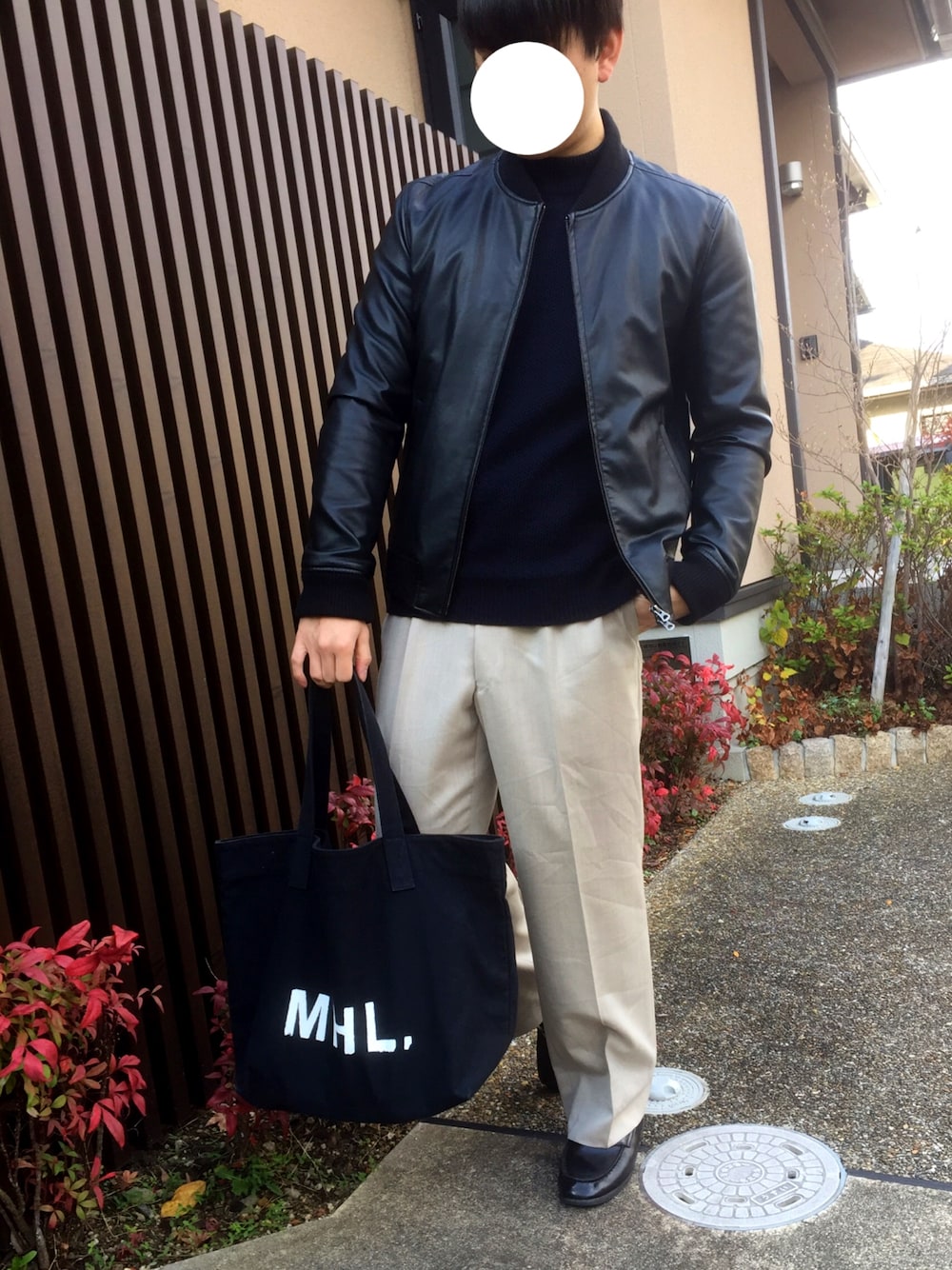 ブラック系のブルゾン、ブラック系のニット/セーター、ベージュ系のスラックスを着用したメンズの冬コーディネートの1枚目の写真