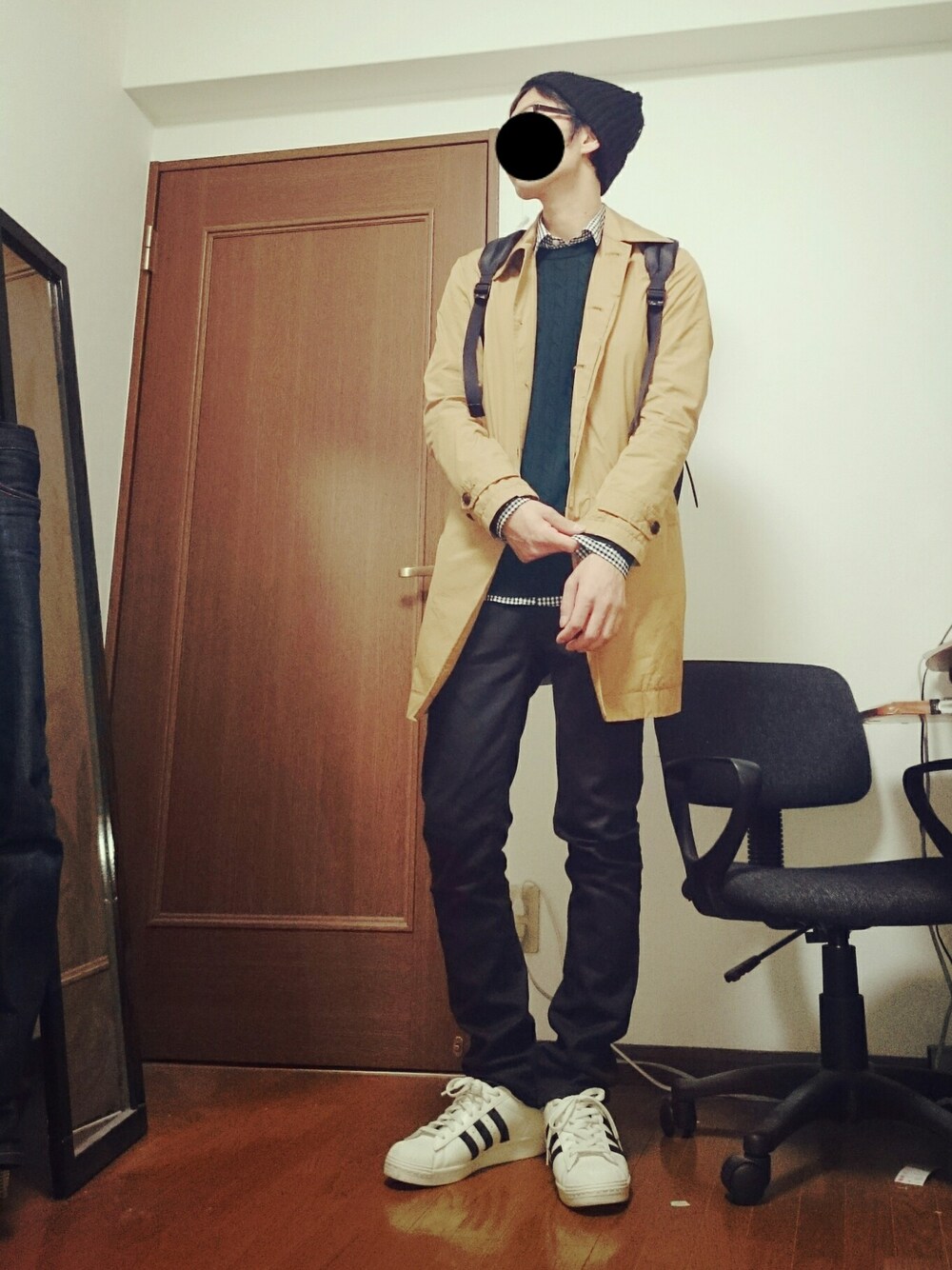 ホワイト系のスニーカー、ベージュ系のステンカラーコート、ブラック系の帽子を着用したメンズの秋コーディネートの1枚目の写真