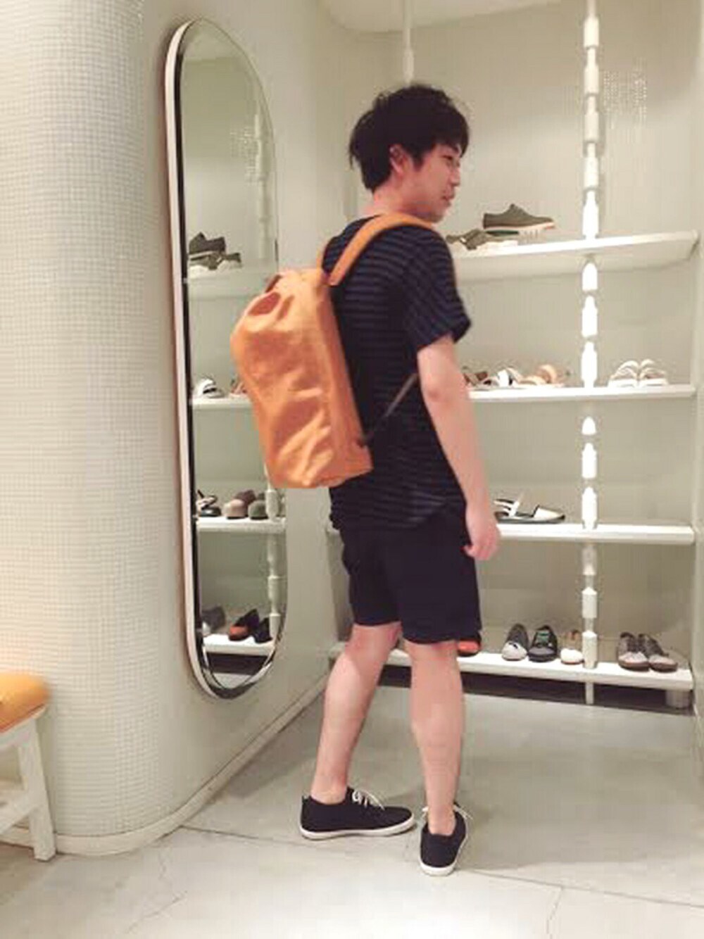 オレンジ系のバックパック/リュック、ブルー系のその他シューズ、ブルー系のTシャツ/カットソーを着用したメンズの春コーディネートの1枚目の写真