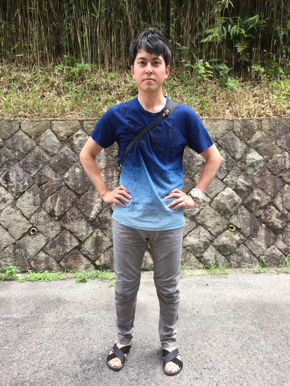 ブルー系のTシャツ/カットソー、グレー系のデニムパンツ、ブラック系のサンダルを着用したメンズの夏コーディネートの1枚目の写真