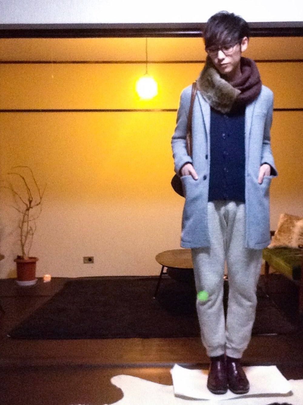 グレー系のチェスターコート、ブルー系のカーディガン/ボレロ、ベージュ系のその他パンツを着用したメンズの冬コーディネートの1枚目の写真