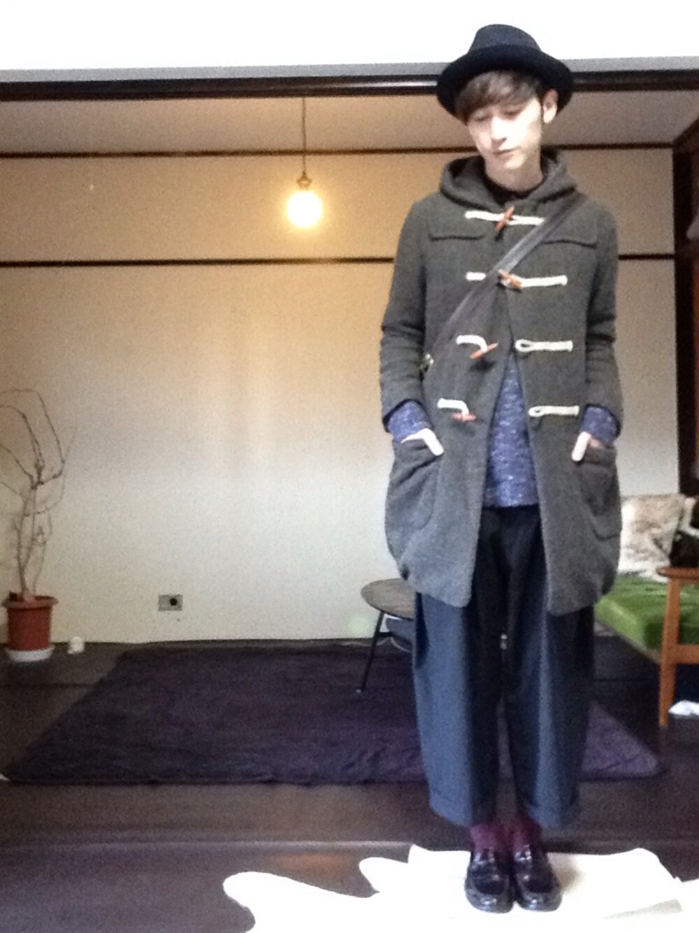 ブラウン系のダッフルコート、その他のニット/セーター、ブラック系のその他パンツを着用したメンズの冬コーディネートの1枚目の写真