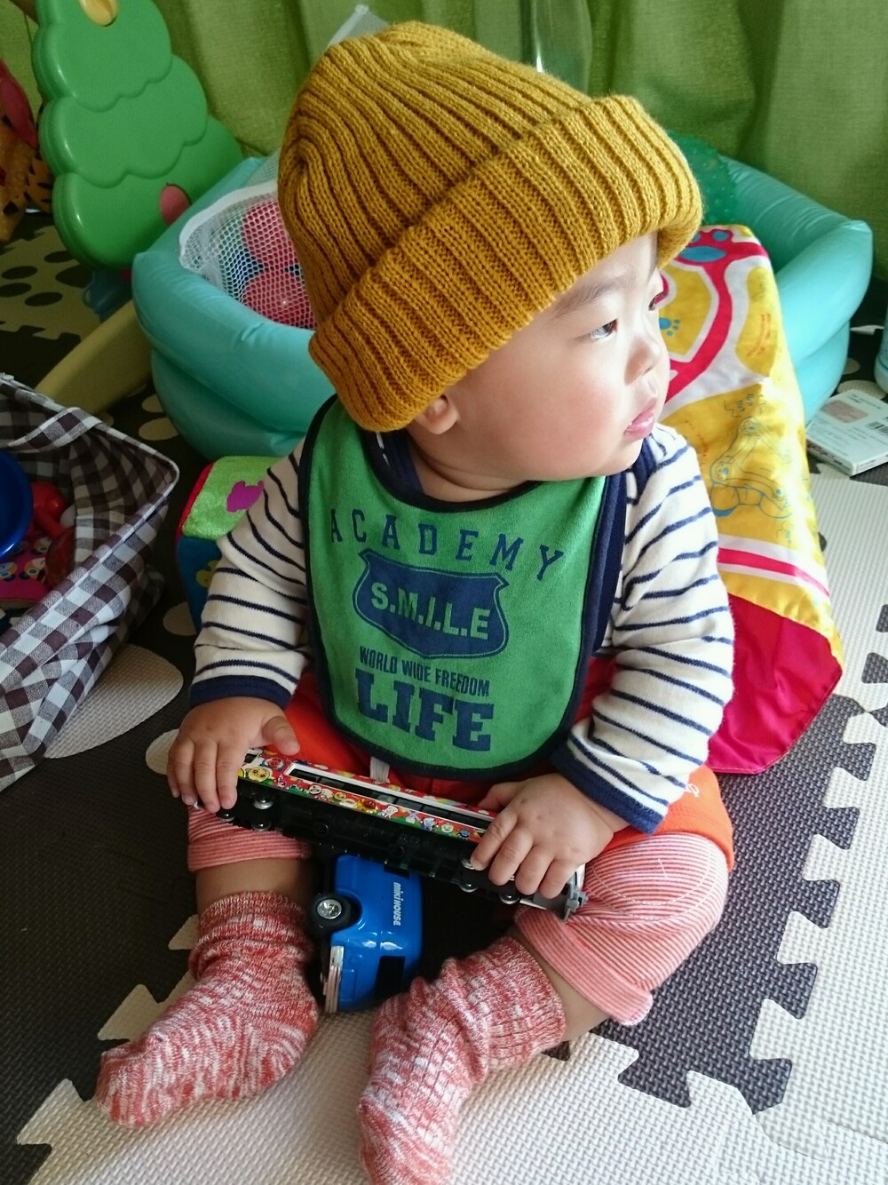 イエロー系の帽子、グリーン系のママ＆ベビー、ホワイト系のママ＆ベビーを着用したキッズの秋コーディネートの1枚目の写真