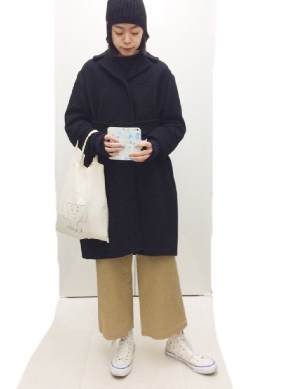 ブルー系のニット/セーター、ブラック系のその他アウター、ベージュ系のその他パンツを着用したレディースの冬コーディネートの1枚目の写真