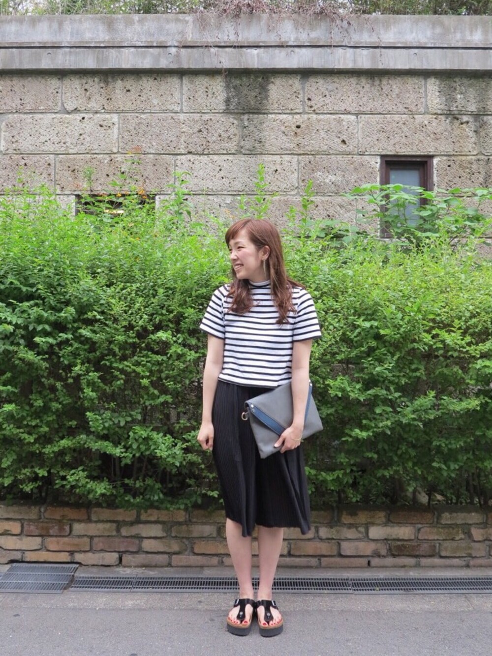 ブラック系のその他パンツ、ブラック系のサンダル、ホワイト系のTシャツ/カットソーを着用したレディースの春コーディネートの1枚目の写真