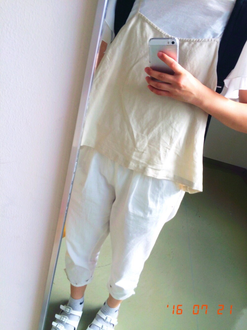 ホワイト系のTシャツ/カットソー、ベージュ系のキャミソール、ブラック系のバックパック/リュックを着用したレディースの夏コーディネートの1枚目の写真