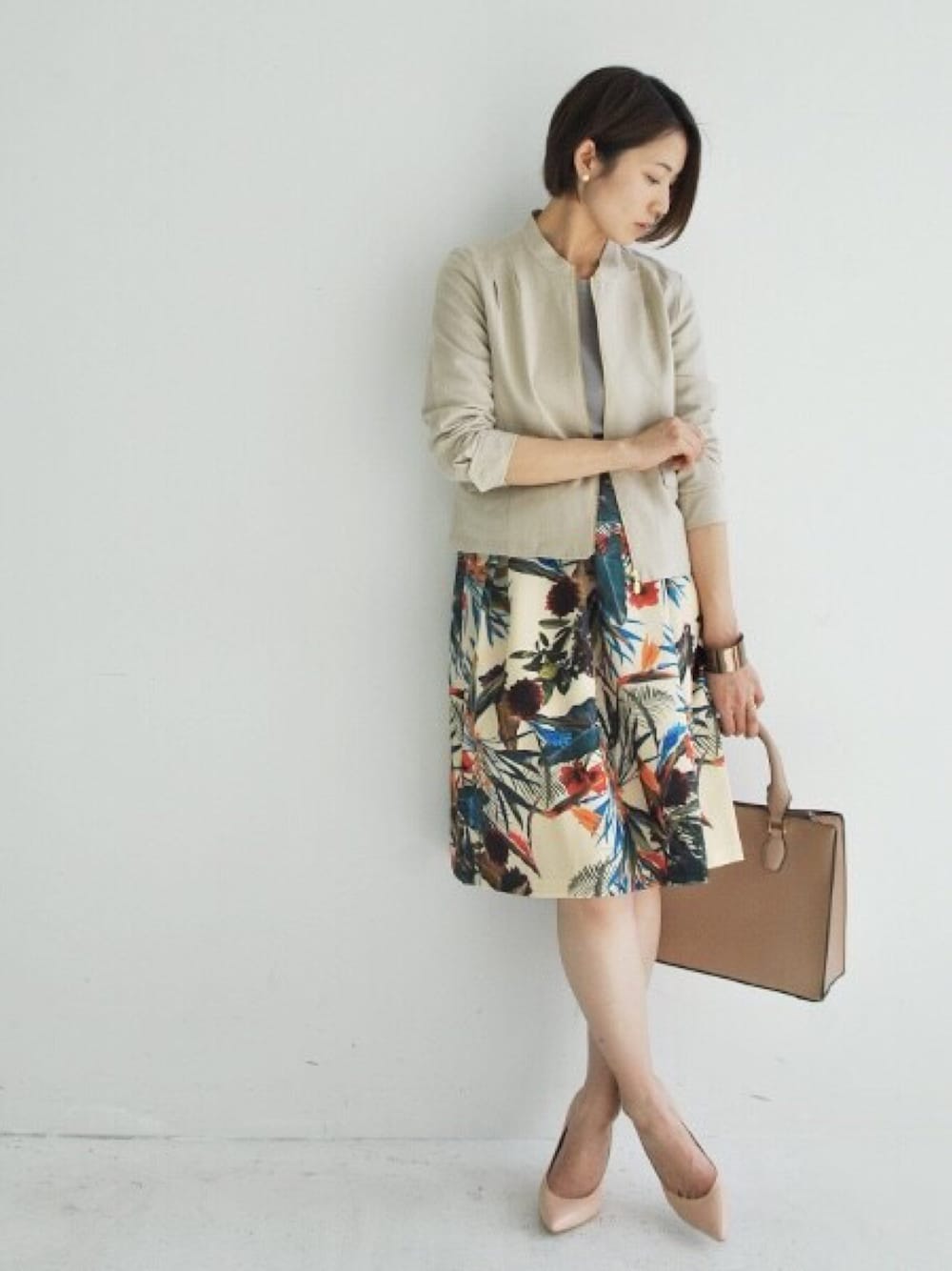 ベージュ系のノーカラージャケット、グレー系のニット/セーター、その他のスカートを着用したレディースの冬コーディネートの1枚目の写真