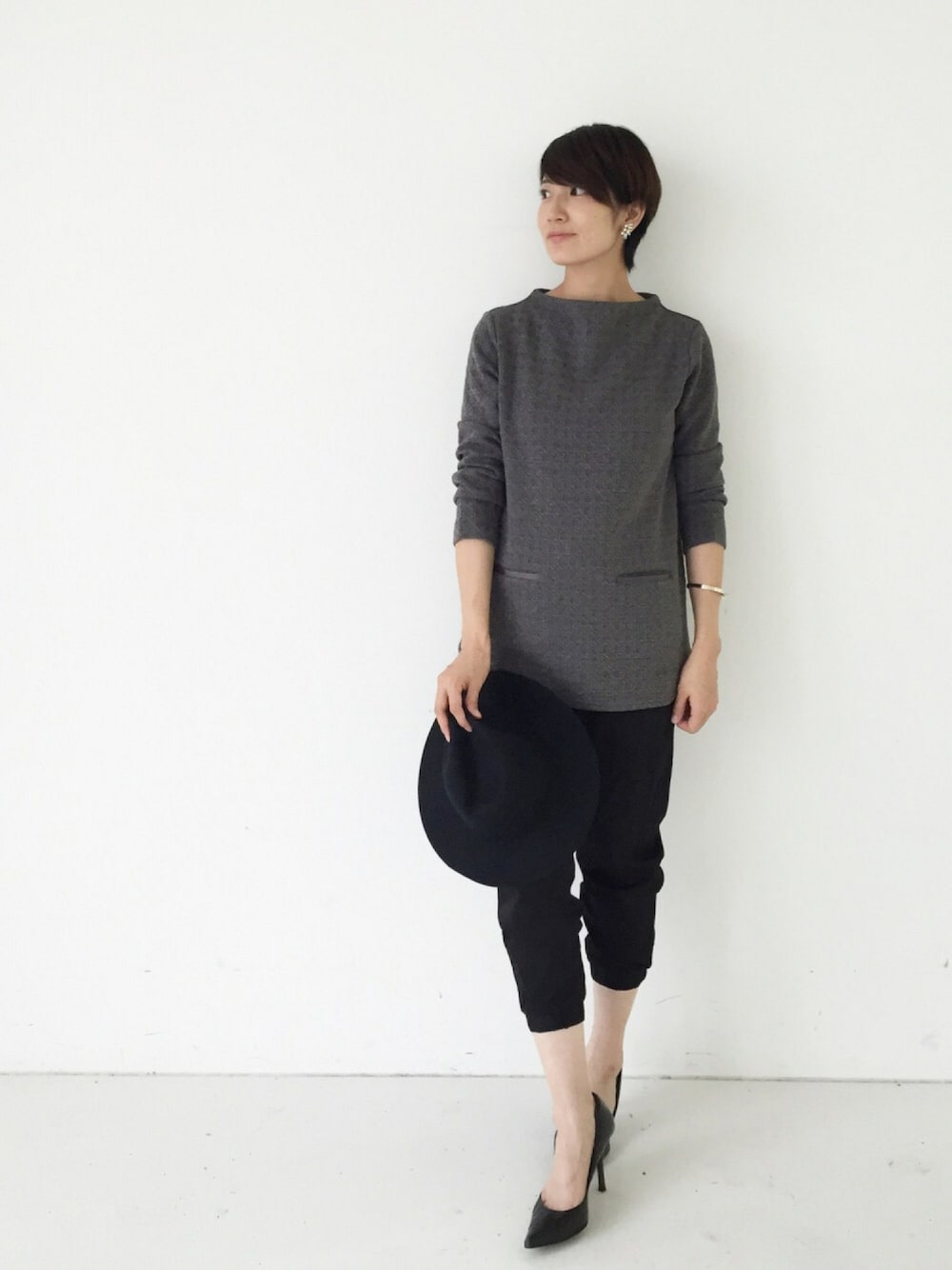 グレー系のチュニック、ブラック系のその他パンツ、ブラック系のパンプスを着用したレディースの秋コーディネートの1枚目の写真