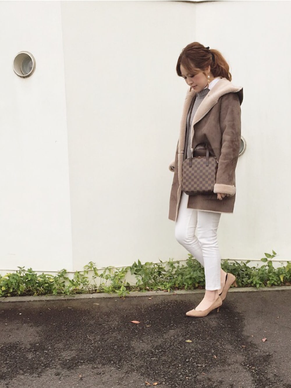 グレー系のムートンコート、ブラウン系のショルダーバッグを着用したレディースの冬コーディネートの1枚目の写真