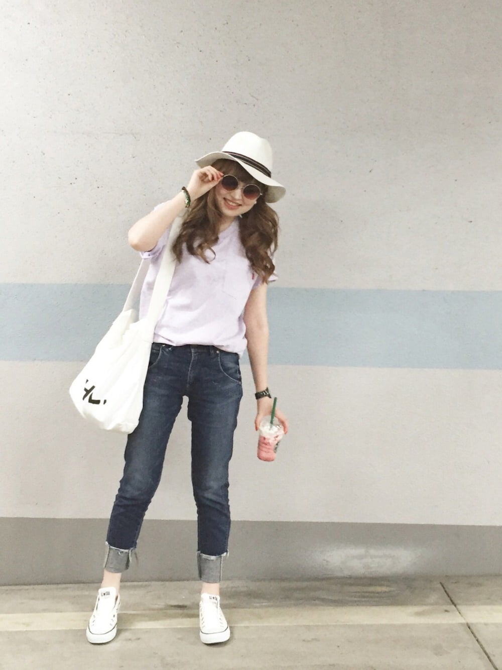 パープル系のTシャツ/カットソー、ホワイト系のバッグ、ブルー系のデニムパンツを着用したレディースの春コーディネートの1枚目の写真