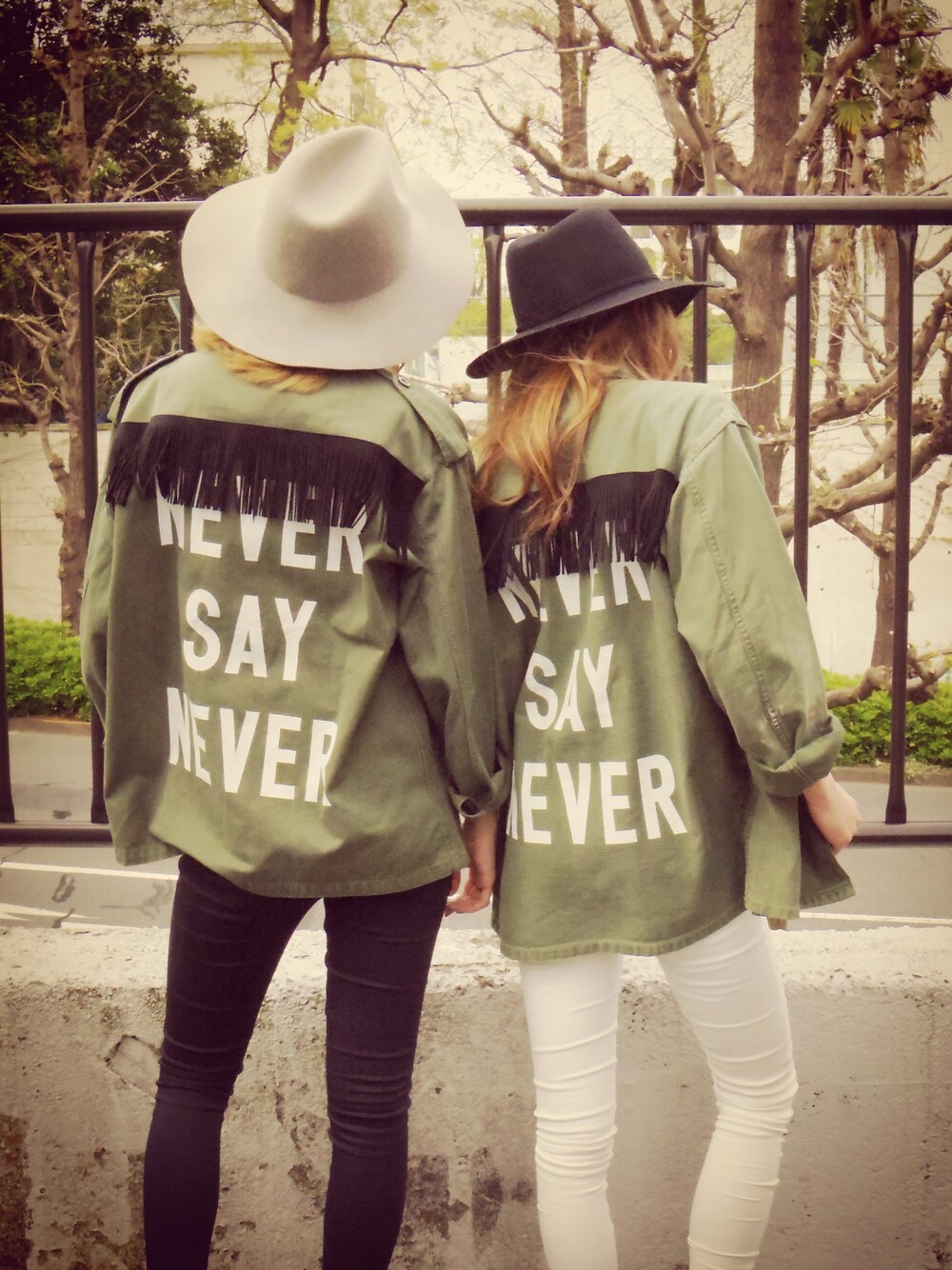 グリーン系のミリタリージャケット、ホワイト系のパンツ、ブラック系のハットを着用したレディースの春コーディネートの1枚目の写真