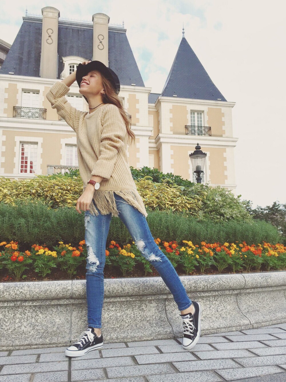 ベージュ系のニット/セーター、ブルー系のデニムパンツ、ブラック系のスニーカーを着用したレディースの秋コーディネートの1枚目の写真