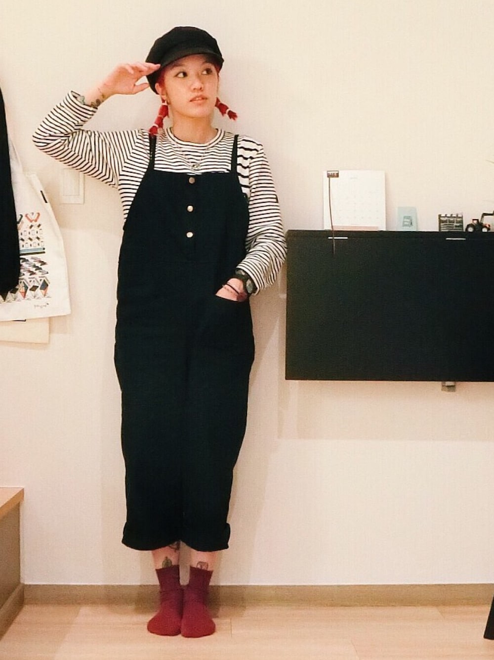 ホワイト系のトップス、ブラック系のサロペット/オーバーオール、ブラック系のハンチング/ベレー帽を着用したレディースの春コーディネートの1枚目の写真