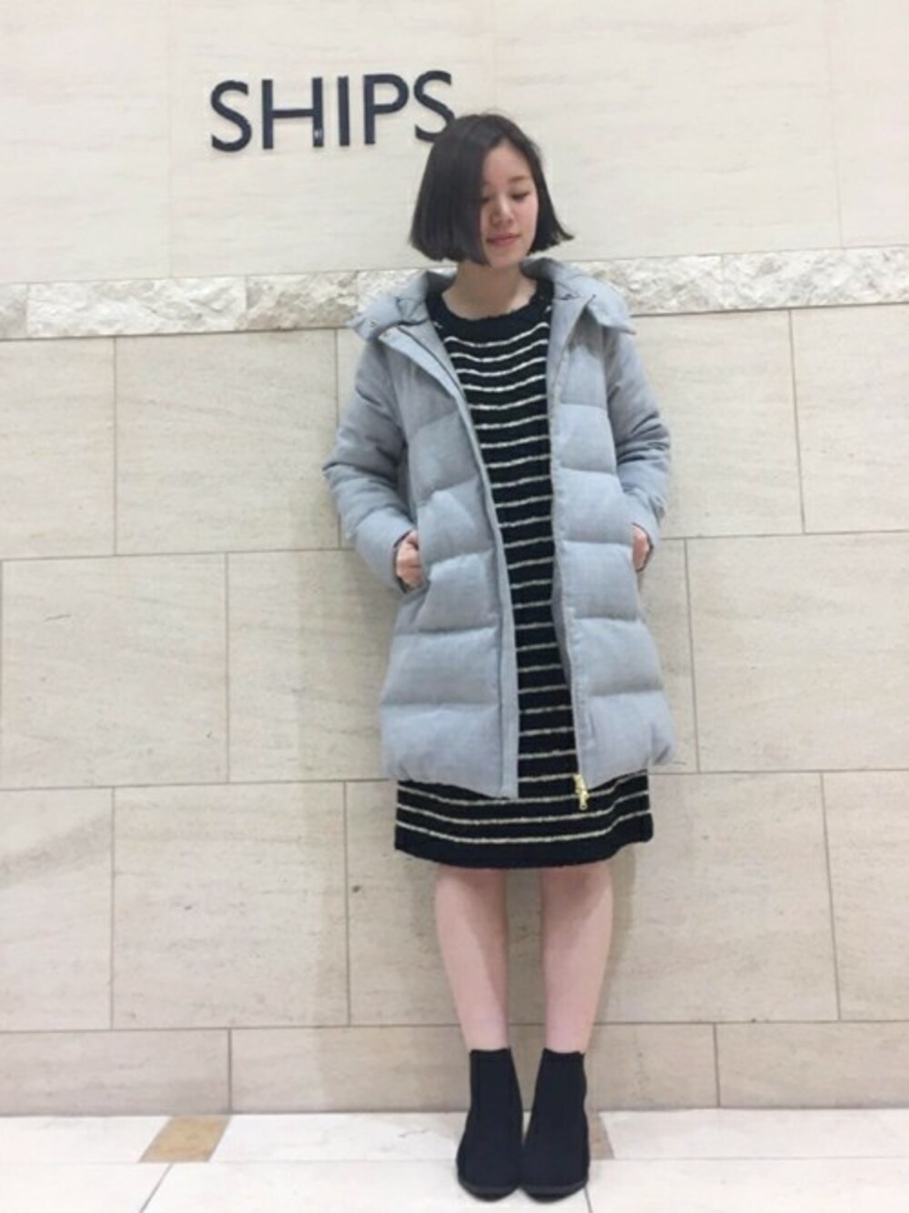 ブラック系のワンピース、グレー系のダウンジャケット/コートを着用したレディースの冬コーディネートの1枚目の写真