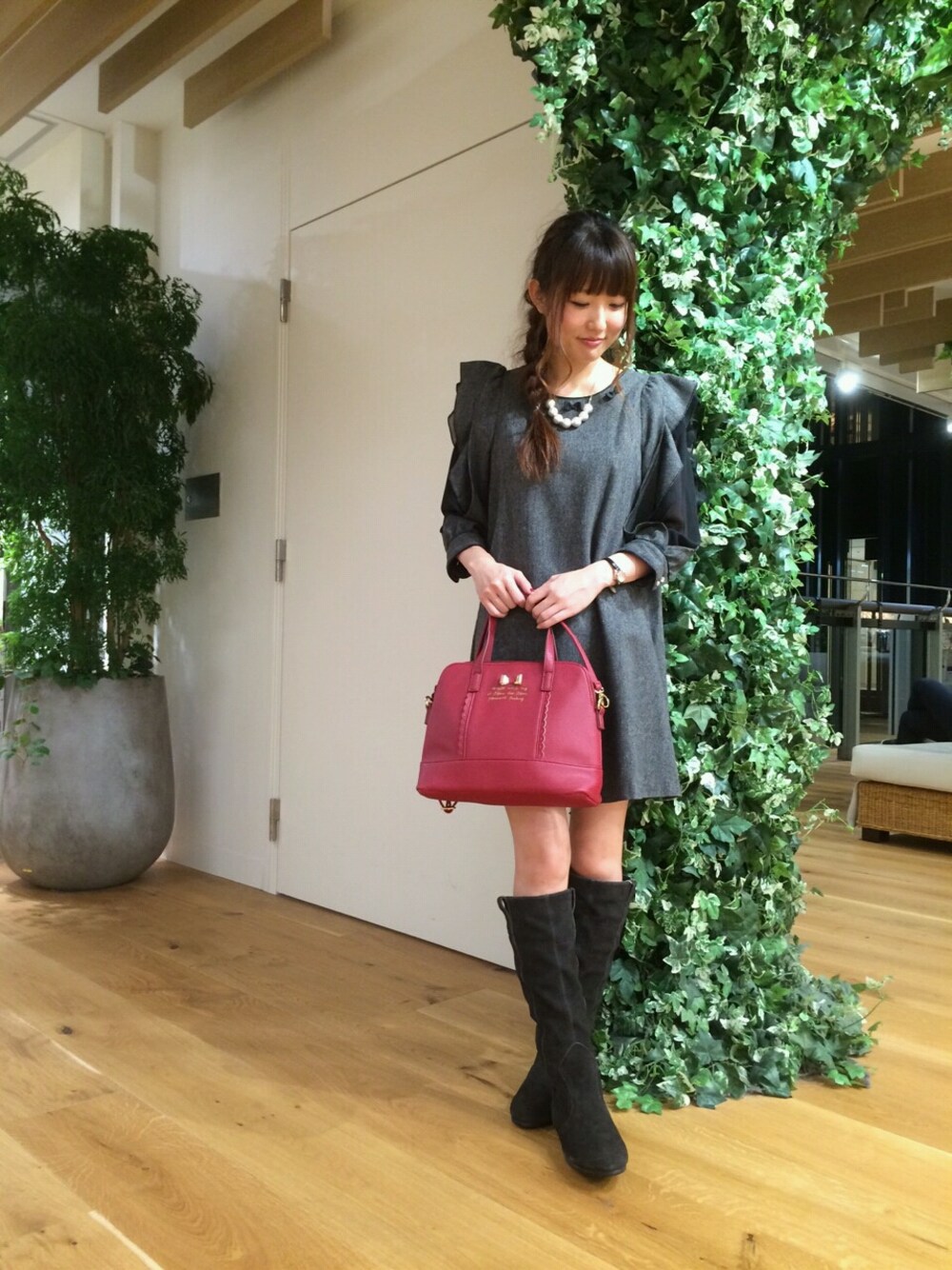 レッド系のボストンバッグ、グレー系のブーツ、ブラック系のワンピース/ドレスを着用したレディースの秋コーディネートの1枚目の写真