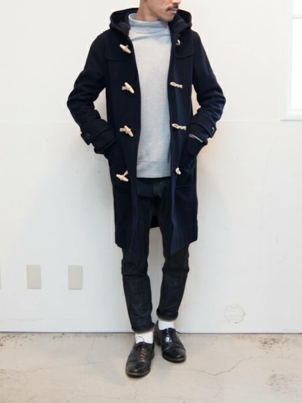 ブルー系のダッフルコート、ブルー系のデニムパンツを着用したメンズの冬コーディネートの1枚目の写真