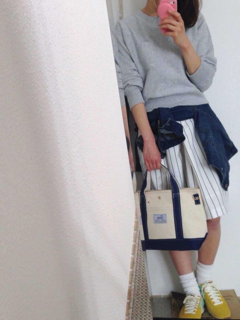 グレー系のTシャツ/カットソー、ブルー系のデニムジャケット、ホワイト系のトートバッグを着用したレディースの春コーディネートの1枚目の写真